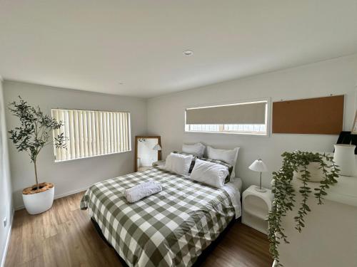 a bedroom with a bed with a plaid blanket at Cosy 3 Bedroom Home near airport with free parking in Auckland