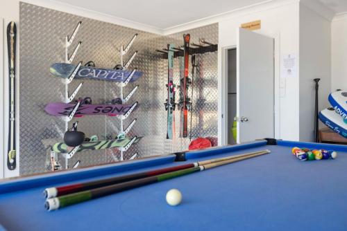 a room with a pool table with balls and bats at Mountain G O A T - Wood Fired Hot Tub, Pool Table, Bike Storage, Ski Drying Room, Perfect for biking or ski trips! in Jindabyne