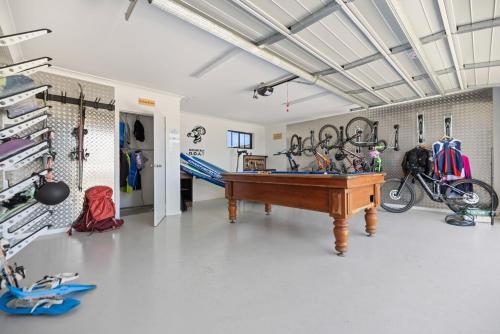a room with a pool table in the middle of it at Mountain G O A T - Wood Fired Hot Tub, Pool Table, Bike Storage, Ski Drying Room, Perfect for biking or ski trips! in Jindabyne