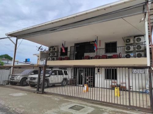 a building with cars parked in a parking lot at House 11 in Lahad Datu
