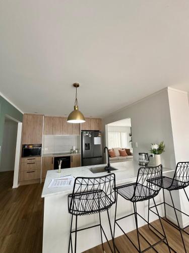 a kitchen with a table and four chairs in a room at Cosy 3 Bedroom Home near airport with free parking in Auckland