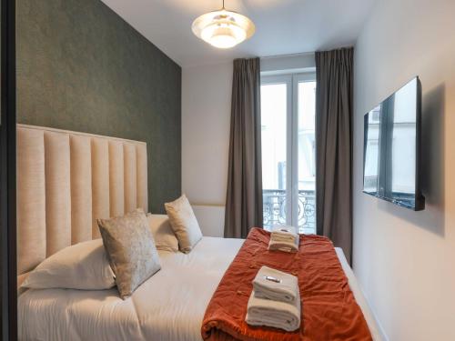 une chambre avec un lit et une télévision au mur dans l'établissement Magnificent apartment - 4BR 10P - Arc de Triomphe, à Paris