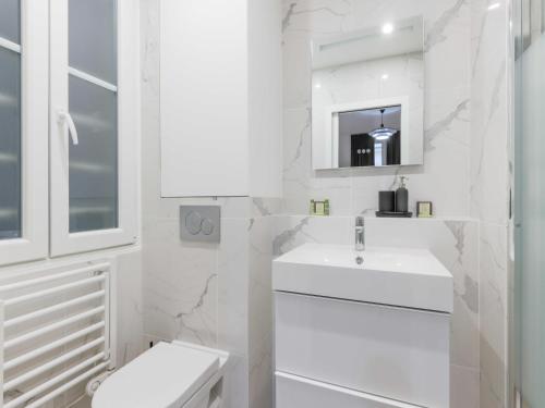 une salle de bain blanche avec un lavabo et des toilettes dans l'établissement Magnificent apartment - 4BR 10P - Arc de Triomphe, à Paris
