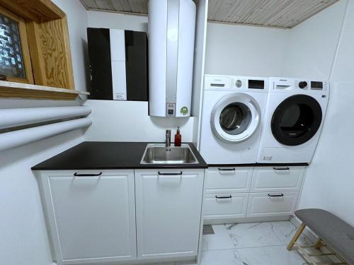 a kitchen with a sink and a washer and dryer at Cozy Coastal Home in Egernsund in Egernsund