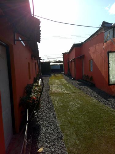 an alley between two red buildings with flowers on the side at Residencial D' Caché in Aguadulce