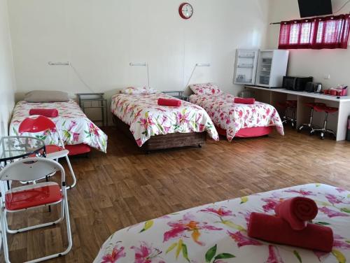 three beds in a room with wooden floors at Blackbutt Motel in Blackbutt