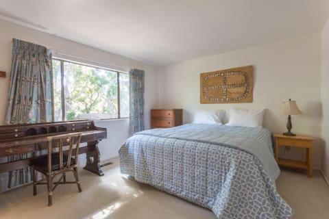 a bedroom with a bed and a desk and a piano at The Forest Knook in Pebble Beach in Del Monte Forest