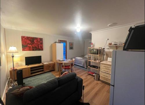 a living room with a couch and a refrigerator at The Blue House in Lake Tyers