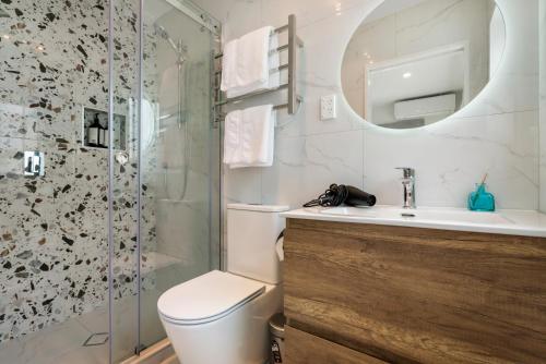 a bathroom with a shower and a toilet and a sink at Auckland Golden Phoenix Holiday Homes in Auckland