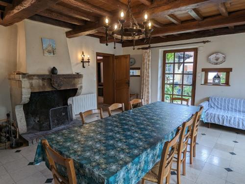 une salle à manger avec une table et une cheminée dans l'établissement Gîte rénové avec jardin clos, cheminée et baby-foot à Contrisson, proche du Lac du Der. - FR-1-585-16, à Contrisson