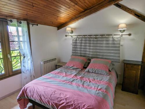 a bedroom with a large bed with pink sheets at Gîte rénové avec jardin clos, cheminée et baby-foot à Contrisson, proche du Lac du Der. - FR-1-585-16 in Contrisson