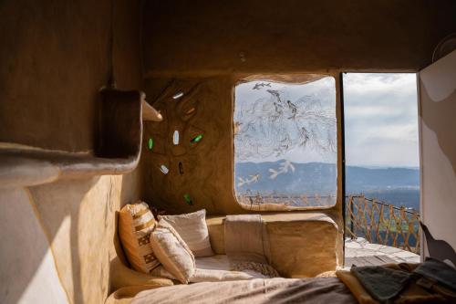 a room with a couch in front of two windows at Paarli Dhara,Bir in Bīr