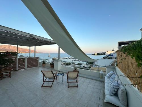 a patio with chairs and a view of the ocean at KYMA sea view apartment 40 meters from the beach in Makry Gialos