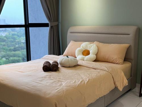 a bed with two stuffed animals on it with a window at 1506 SkyTree Bukit Indah Aeon 1min in Johor Bahru