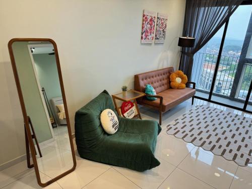 a living room with a mirror and a green chair at 1506 SkyTree Bukit Indah Aeon 1min in Johor Bahru