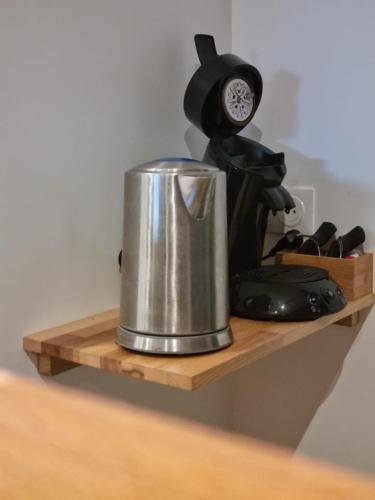 une cafetière sur une étagère en bois avec une horloge dans l'établissement Marafiki Etretat, à Percoq