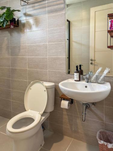 a bathroom with a toilet and a sink at Cozy Botanical Garden House in Batam Center