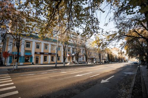 an empty city street with trees and buildings at Dosoftei Residence in Chişinău