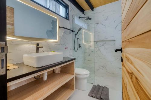 a bathroom with a sink and a mirror at Echo Haven A2 1BR Loft In Canggu in Canggu