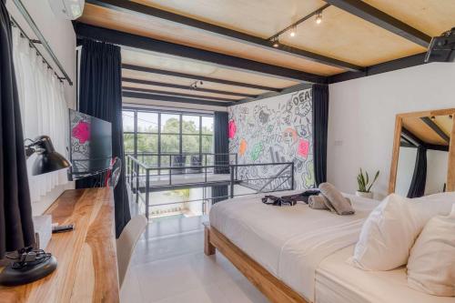 a bedroom with a large bed and a balcony at Echo Haven A2 1BR Loft In Canggu in Canggu