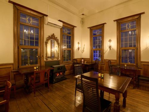 a dining room with tables and a wood stove at Tabist Kaihorow Otaru in Otaru