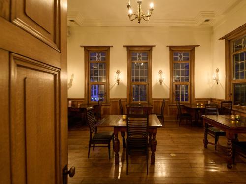 a dining room with tables and chairs and a chandelier at Tabist Kaihorow Otaru in Otaru