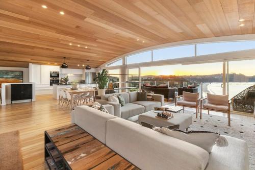 a living room filled with furniture and a large window at GARRATT VIEW - Coast & Country in Waiheke Island