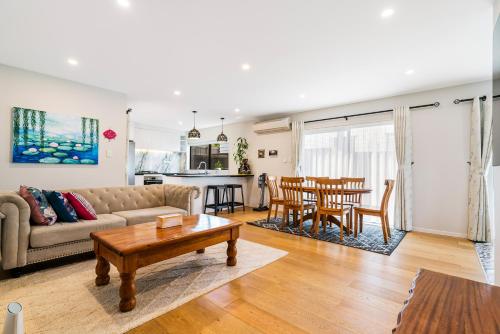 a living room with a couch and a table at Auckland Golden Phoenix Holiday Homes in Auckland
