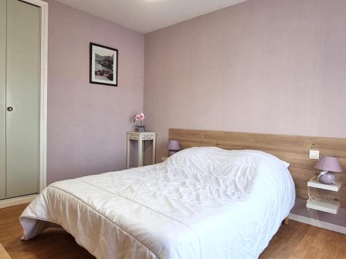 a bedroom with a white bed with a wooden headboard at Port-Vendres - Appartement F3 avec parking et WIFI - FR-1-309-241 in Port-Vendres