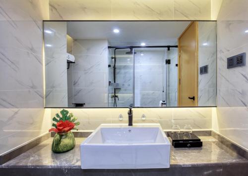 a bathroom with a sink and a large mirror at Songshe Hotel - Yangshuo West Street in Yangshuo