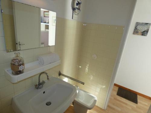 une salle de bain blanche avec un lavabo et un miroir dans l'établissement Studio bord de mer, balcon, animaux bienvenus, parking - Notre-Dame-de-Monts - FR-1-540-315, à Notre-Dame-de-Monts