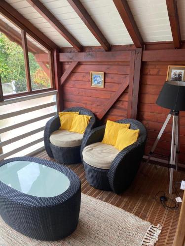 a screened in porch with two chairs and a table at Tite halte in Saint-Claude