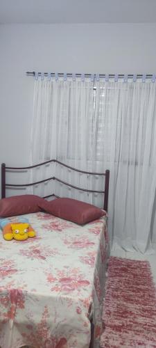 ein Schlafzimmer mit einem Bett mit einem weißen Vorhang in der Unterkunft Casa de veraneio in Caraguatatuba