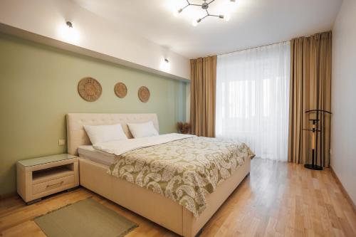 a bedroom with a large bed and a window at Dosoftei Residence in Chişinău