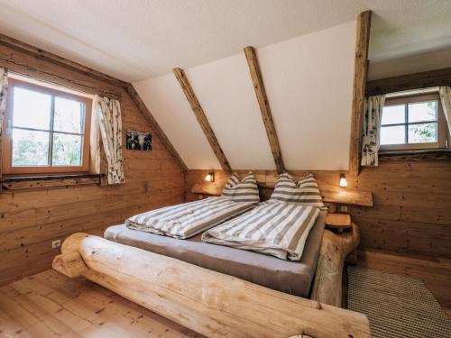 a bedroom with a bed with a large tree log at Webertonihütte Modern retreat in Kliening