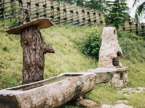 a statue of a tree with a water fountain at Webertonihütte Modern retreat in Kliening