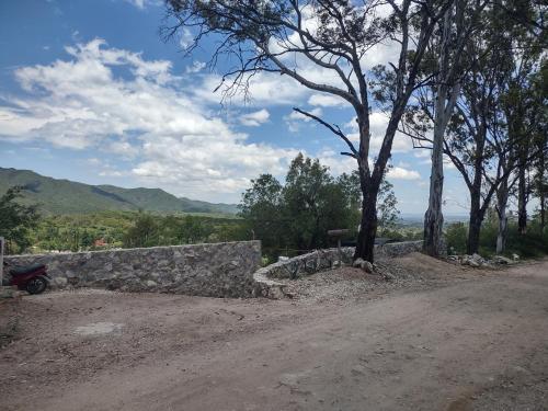 una pared de piedra al lado de un camino de tierra en Refugio del Valle, en La Falda