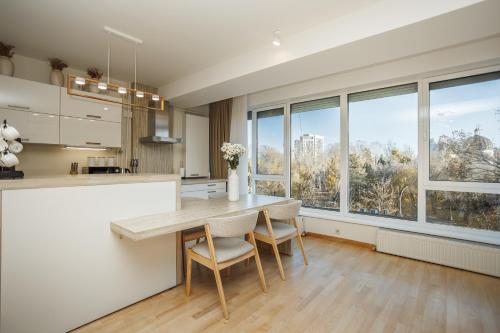 a kitchen with a table and chairs and windows at Dosoftei Residence in Chişinău