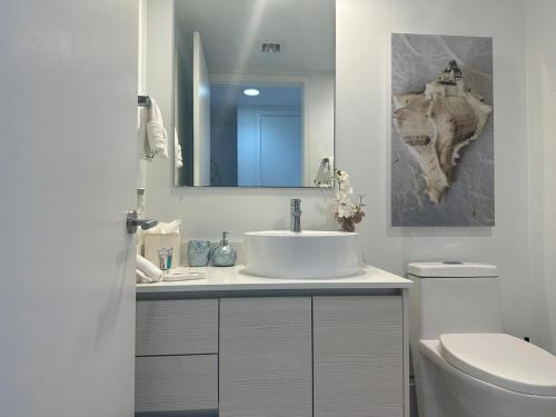 a bathroom with a sink and a toilet and a mirror at Beautiful Studio in Hallandale with Beach & Pool in Hallandale Beach