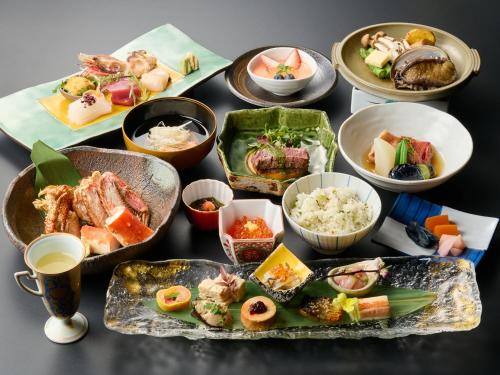 a table with many different dishes of food on it at Tabist Chikuba Shinyotei Hakodate Yunokawaonsen in Hakodate