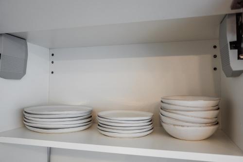 four white plates on a shelf in a kitchen at Dosoftei Residence in Chişinău