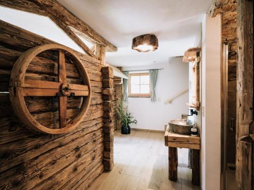 a room with a wooden wall with a large wooden wheel at Webertonihütte Modern retreat in Kliening