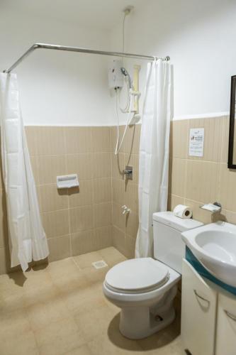 a bathroom with a toilet and a shower and a sink at Palmbeach Resort Mactan Cebu powered by Cocotel in Mactan