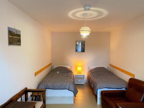 2 Betten in einem Zimmer mit Sofa und Lampe in der Unterkunft Maison familliale près de Chaumont-sur-Loire : calme, bien équipée, idéale pour découvrir les Châteaux. - FR-1-491-379 in Chaumont-sur-Loire