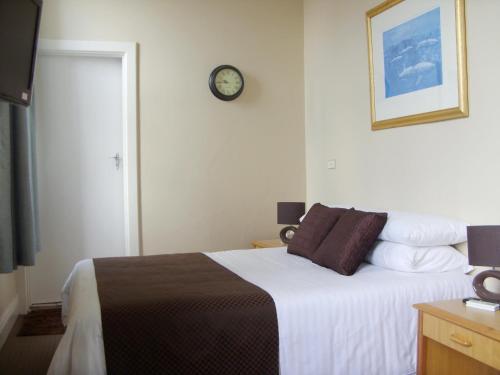 CollieにあるThe Colliefields Hotelのベッドルーム1室(壁に時計付)