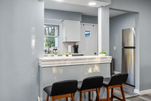 a kitchen with a counter with chairs and a refrigerator at Peaceful Private backyard w BBQ in Lombard by LCP Collection in Lombard
