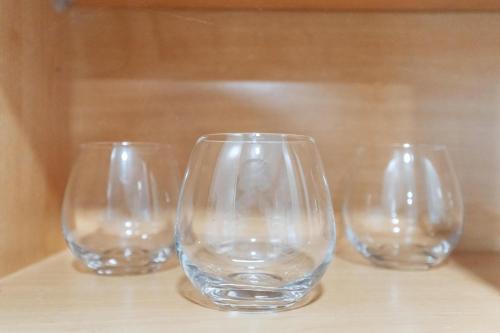 three empty wine glasses sitting on a table at Peaceful Private backyard w BBQ in Lombard by LCP Collection in Lombard