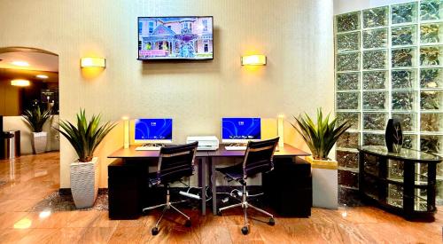 an office with a desk with three computers on it at Best Western Plus Suites Hotel - Los Angeles LAX Airport in Inglewood