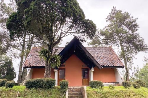 a small house with a tree in front of it at RedDoorz at Argapuri Resort Gambung in Gambung