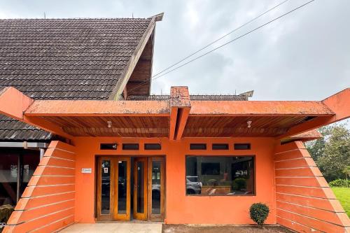 an orange house with a brown roof at RedDoorz at Argapuri Resort Gambung in Gambung